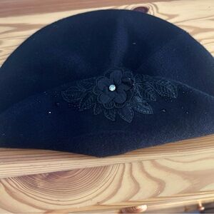 Black beret with floral appliqué.